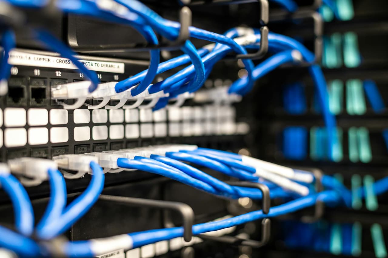 Switch Cisco Catalyst en rack de datacenter con módulos SFP instalados y cables de fibra óptica conectados en infraestructura de red empresarial