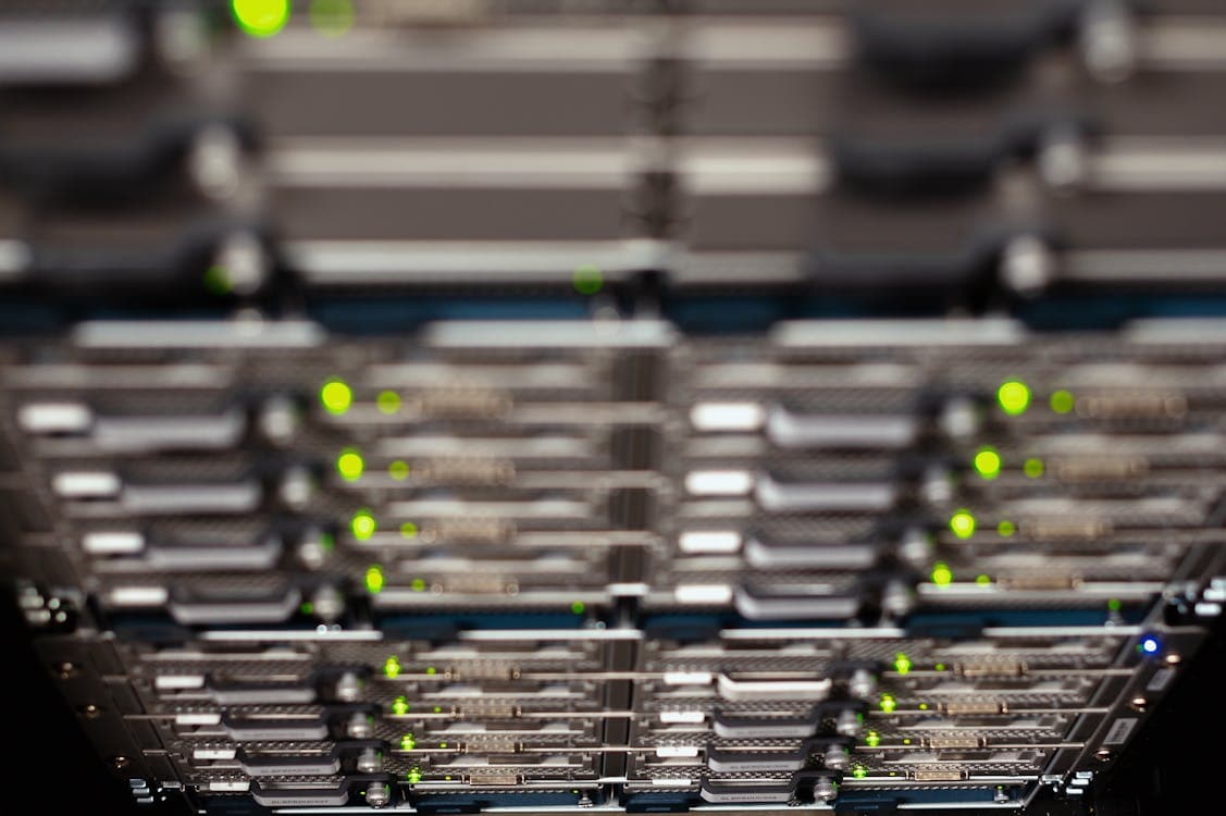 Datacenter con switches Juniper QFX en arquitectura spine-leaf con cables de fibra óptica conectados en múltiples puertos QSFP+, donde los módulos compatibles EON recodificados para JunOS representan el estándar para reducir costos de infraestructura óptica en LATAM